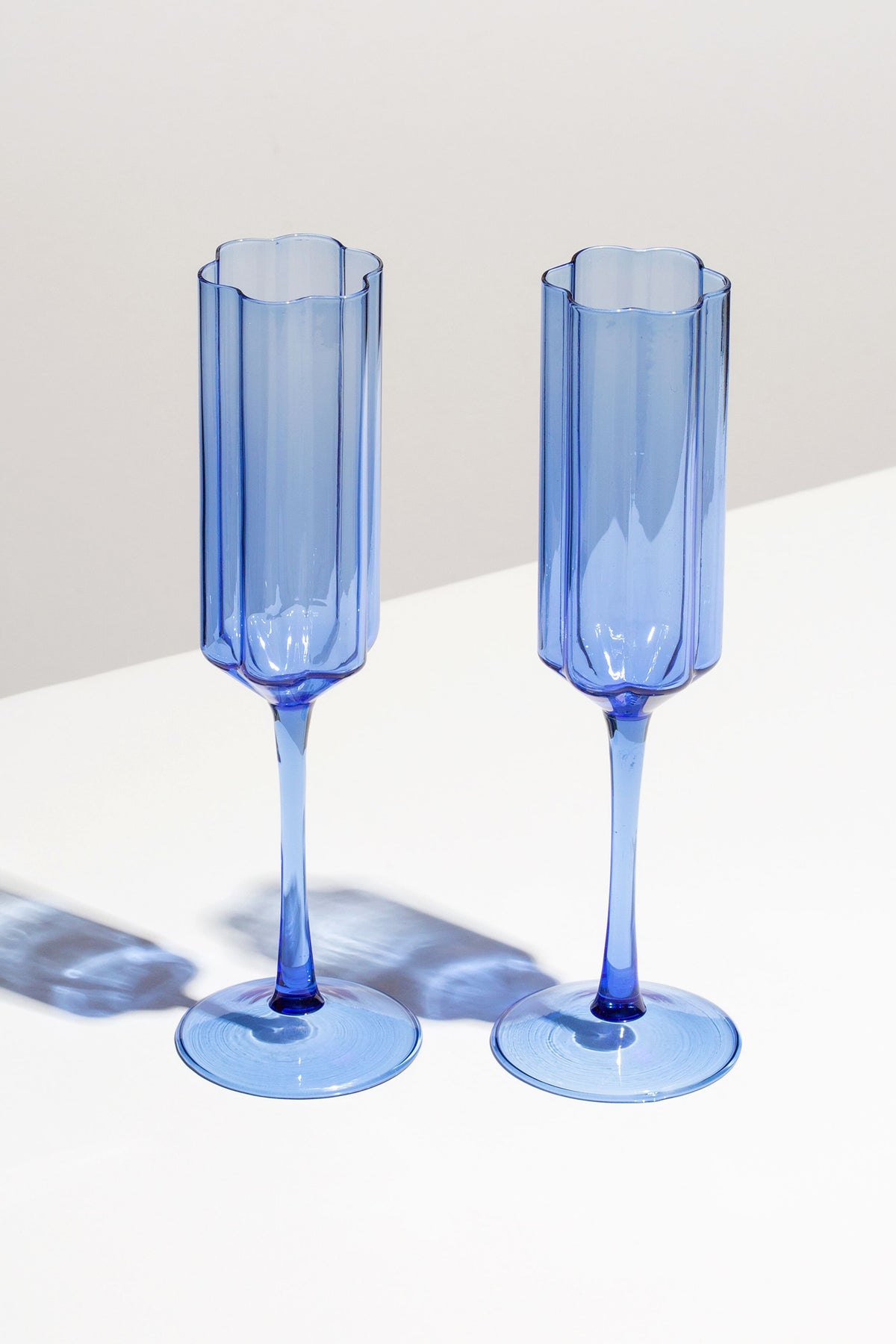 Two FAZEEK Blue Wave Flutes, crafted from borosilicate glass, stand side by side on a white surface with soft shadows behind them.
