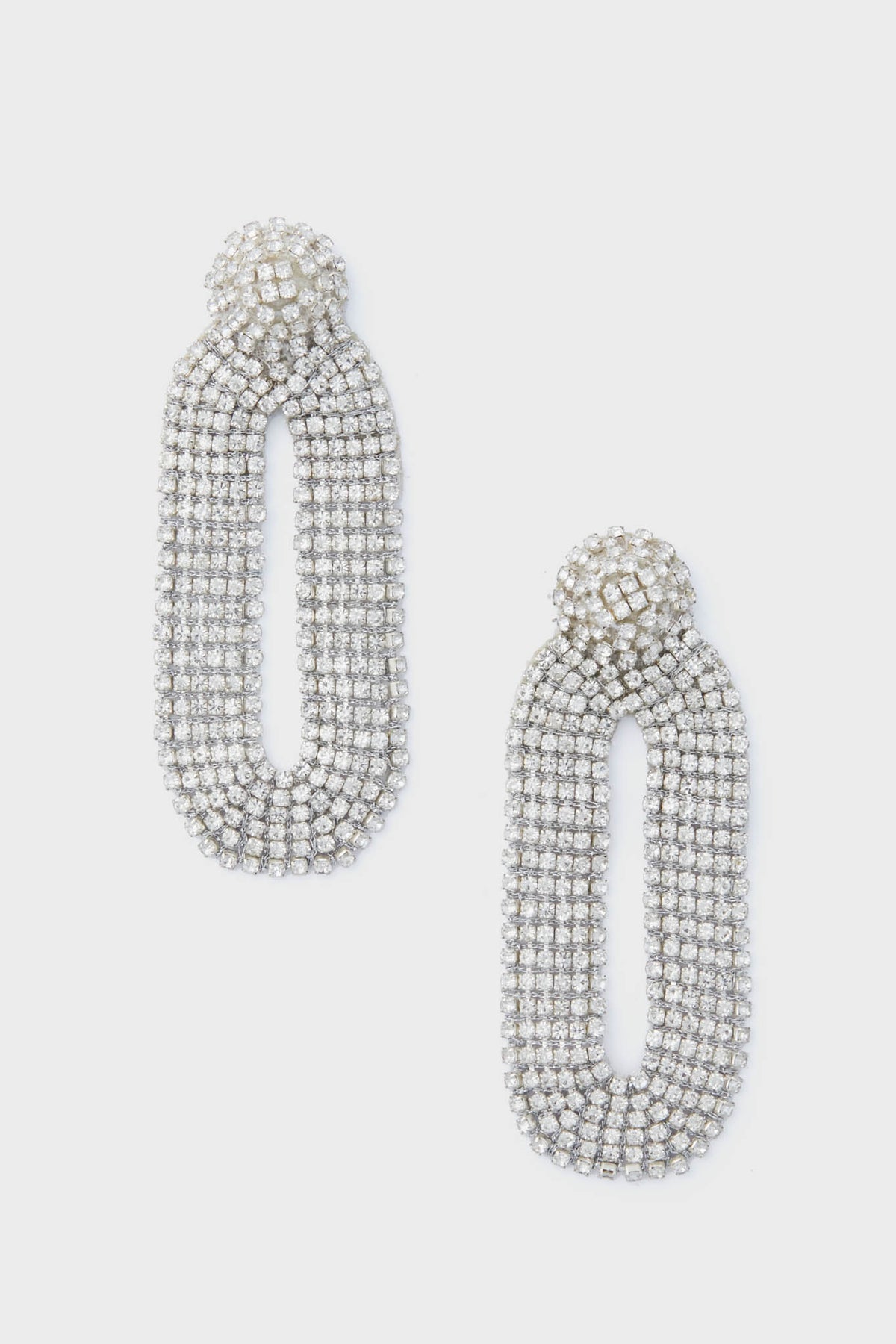 Deepa Gurnani’s silver oval rhinestone statement earrings feature a textured, layered design that captures the allure of handcrafted accessories.