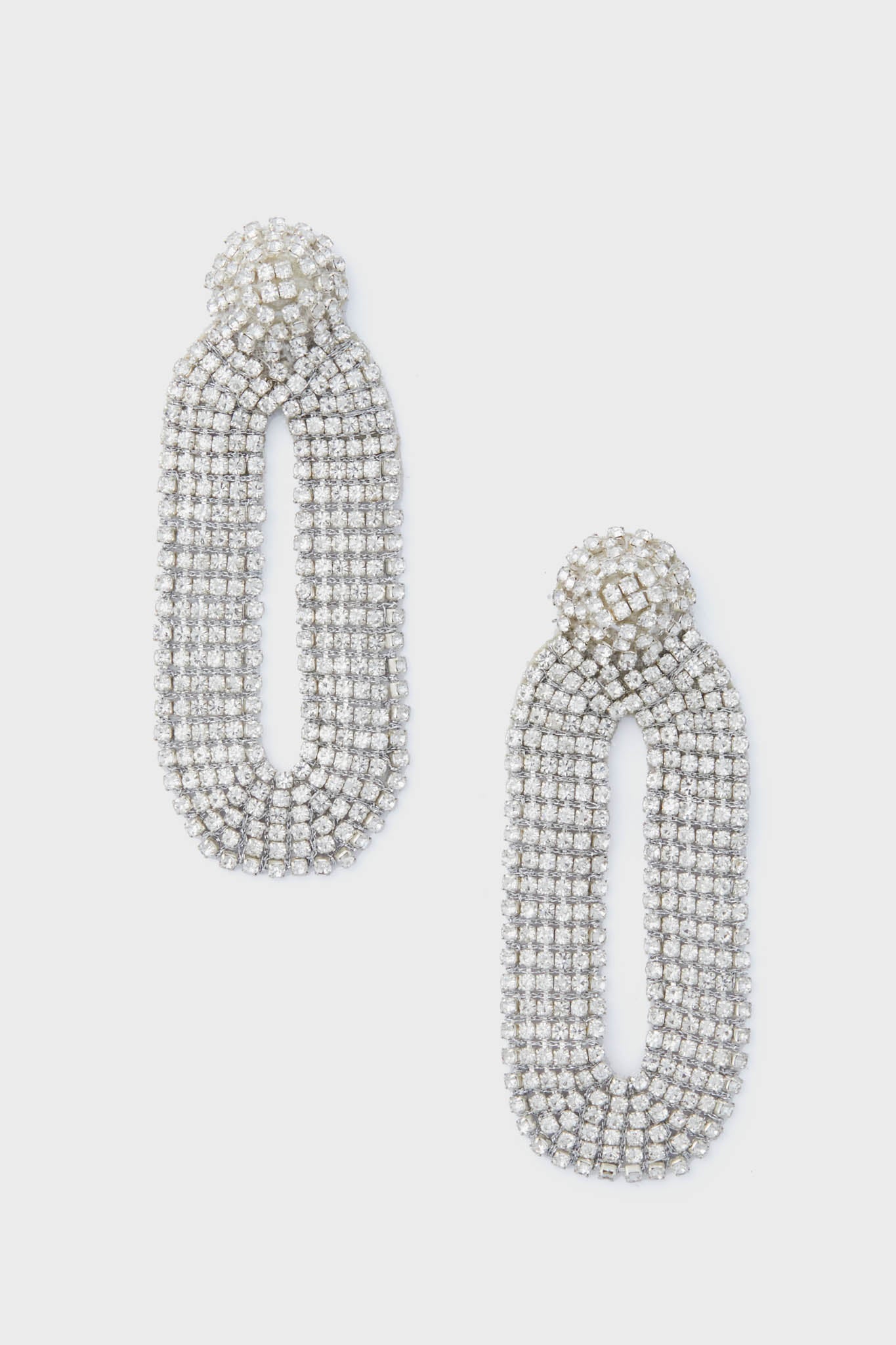 Deepa Gurnani’s silver oval rhinestone statement earrings feature a textured, layered design that captures the allure of handcrafted accessories.