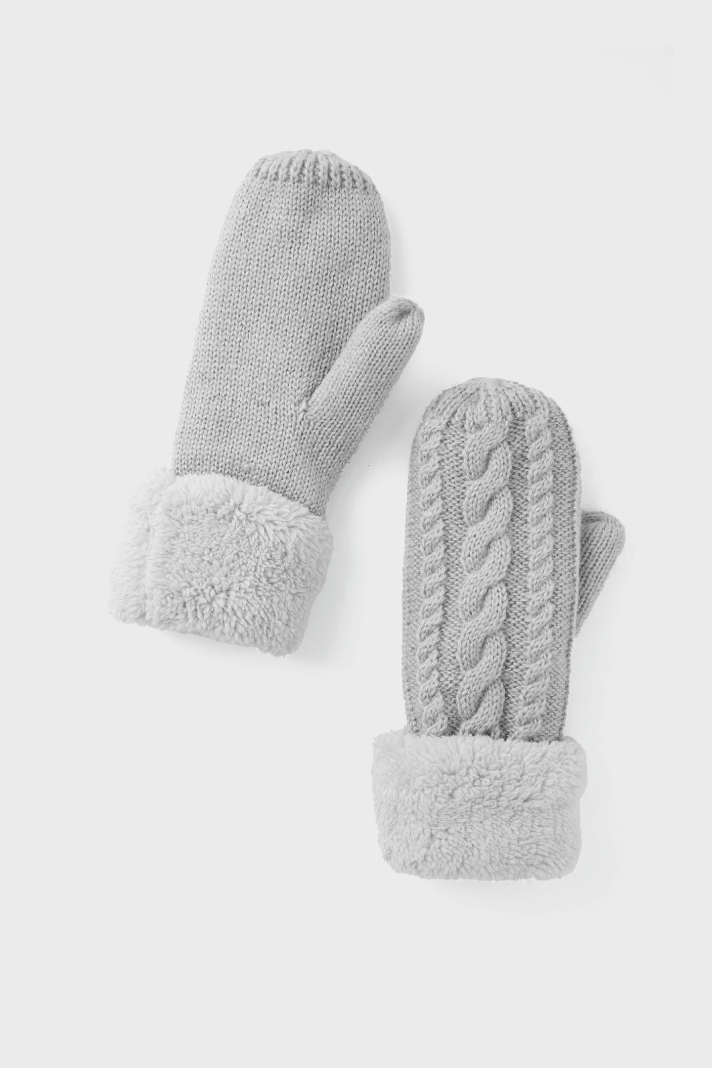 The Hat Attack Light Grey Flurry Mittens feature a braided cable-knit design and faux fur cuffs, making them the perfect cozy and stylish winter accessory.