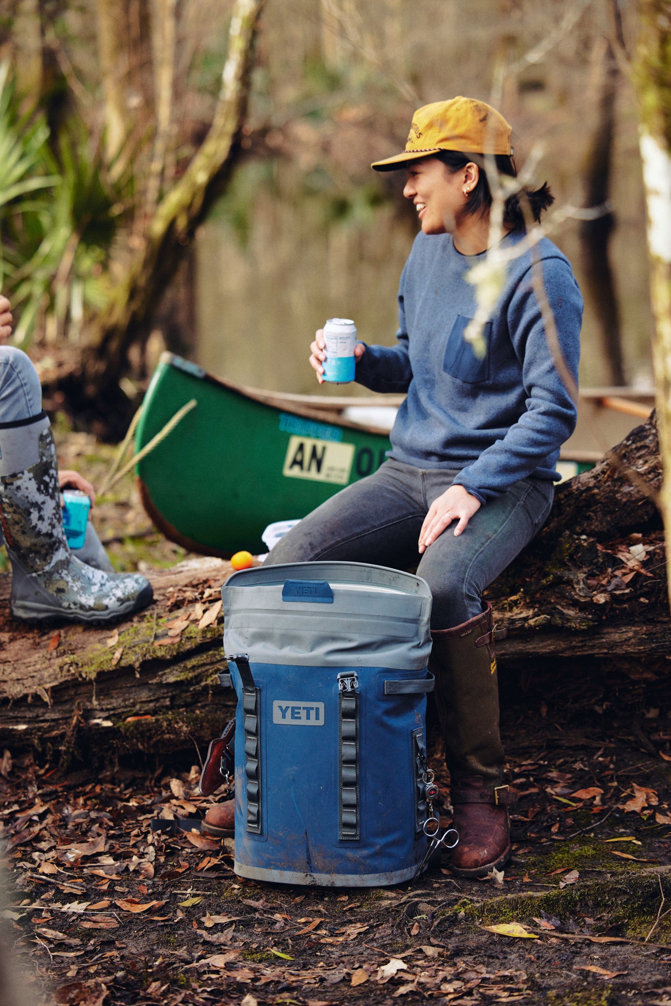 Navy Hopper M20 Backpack effortlessly sits next to a woman in a classic outdoor setting, showcasing its high-end, hands-free design ideal for fun adventures.