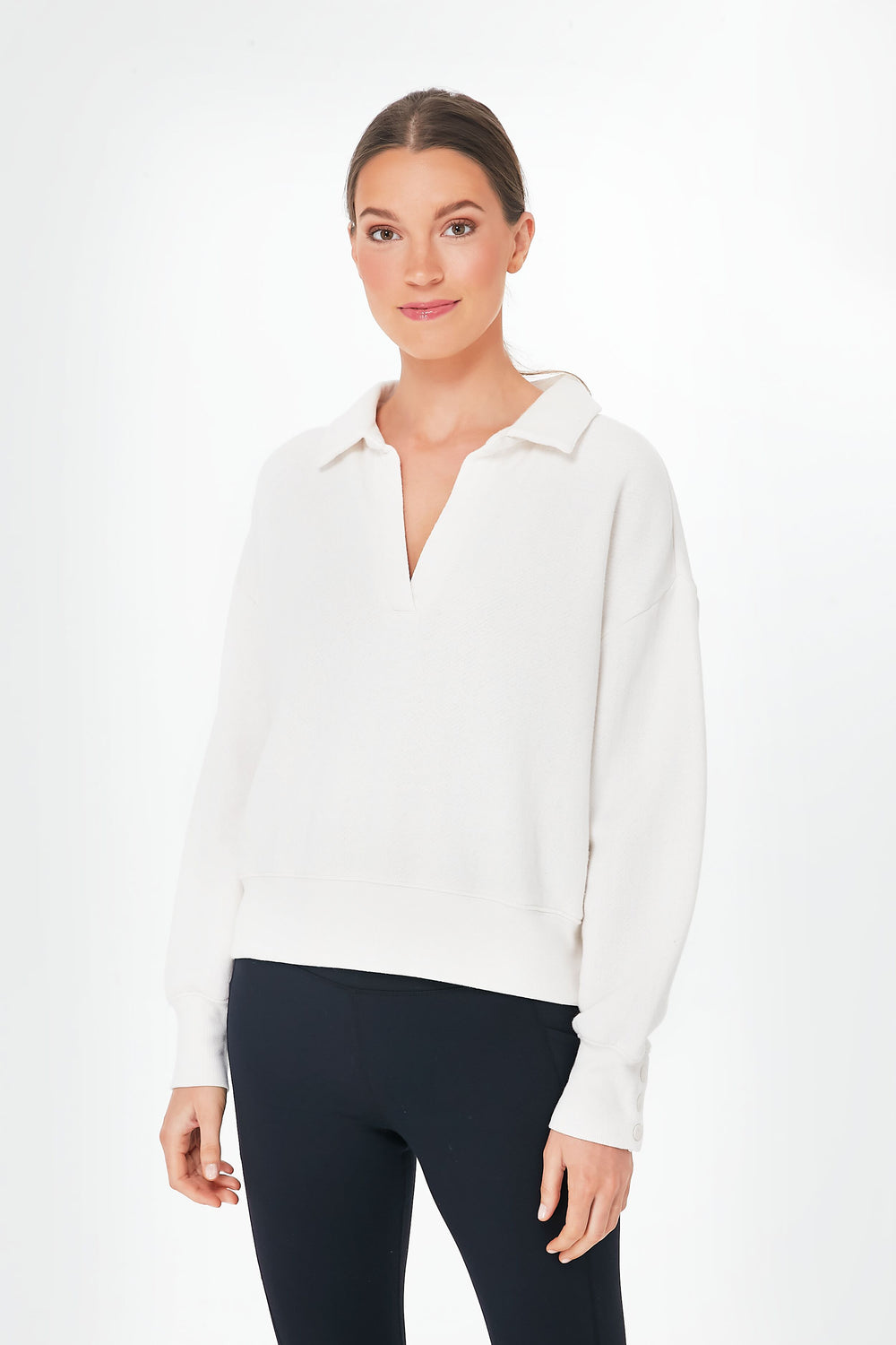 A woman models a white Z SUPPLY collared fleece top with a relaxed fit and black leggings, gazing at the camera with a slight smile.