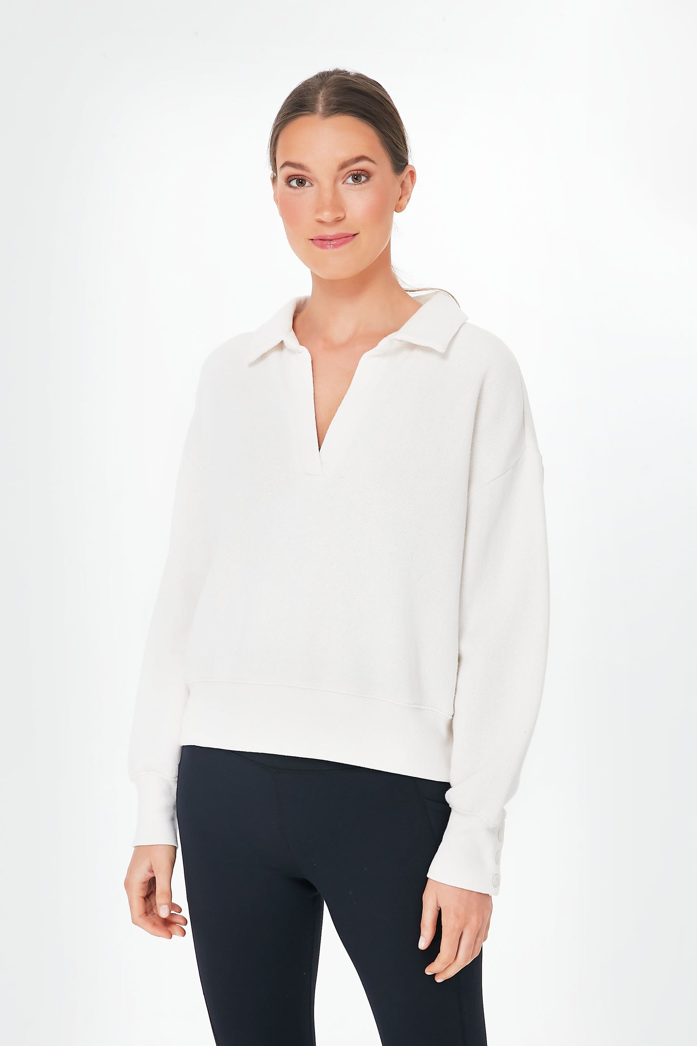 A woman models a white Z SUPPLY collared fleece top with a relaxed fit and black leggings, gazing at the camera with a slight smile.