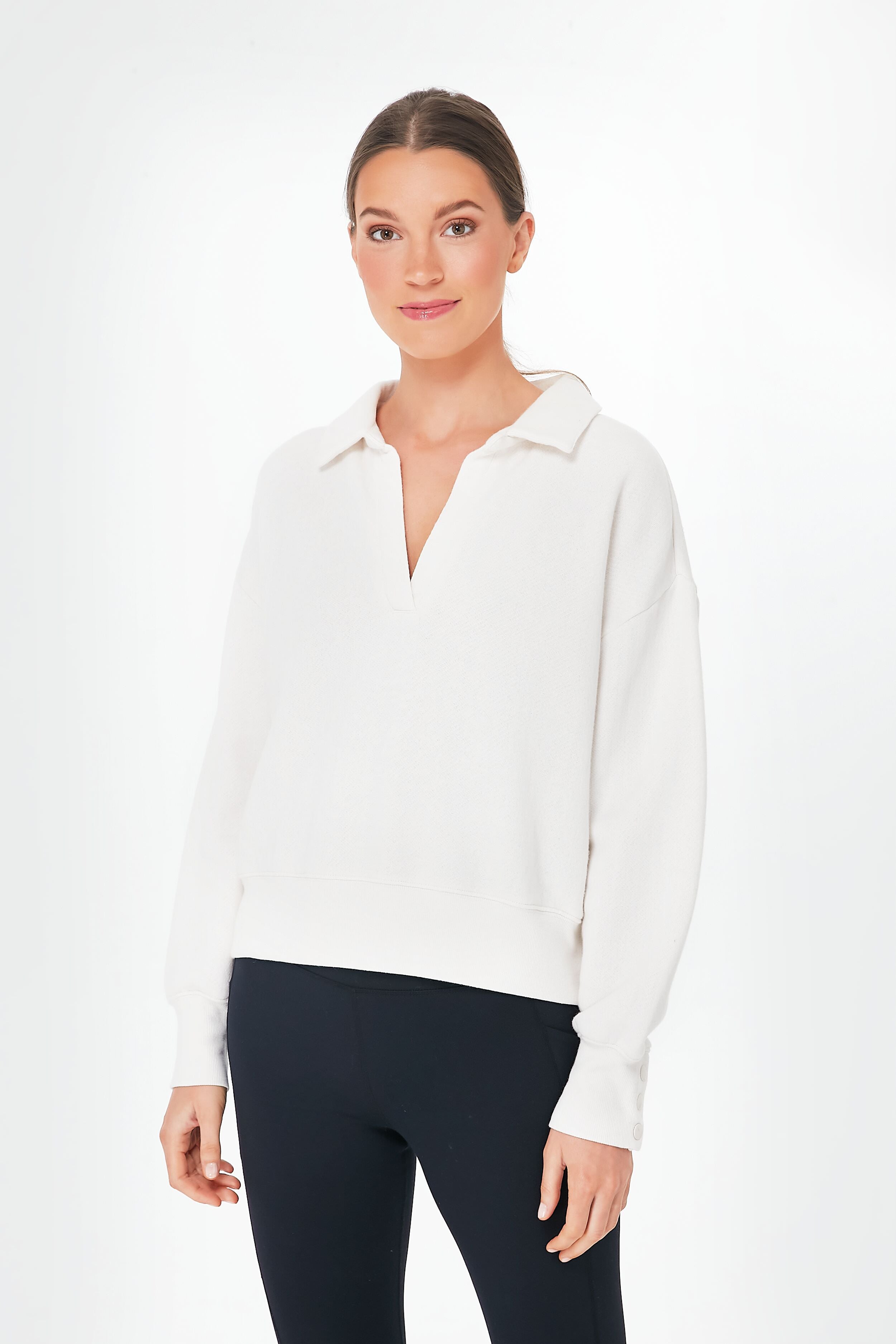 A woman models a white Z SUPPLY collared fleece top with a relaxed fit and black leggings, gazing at the camera with a slight smile.