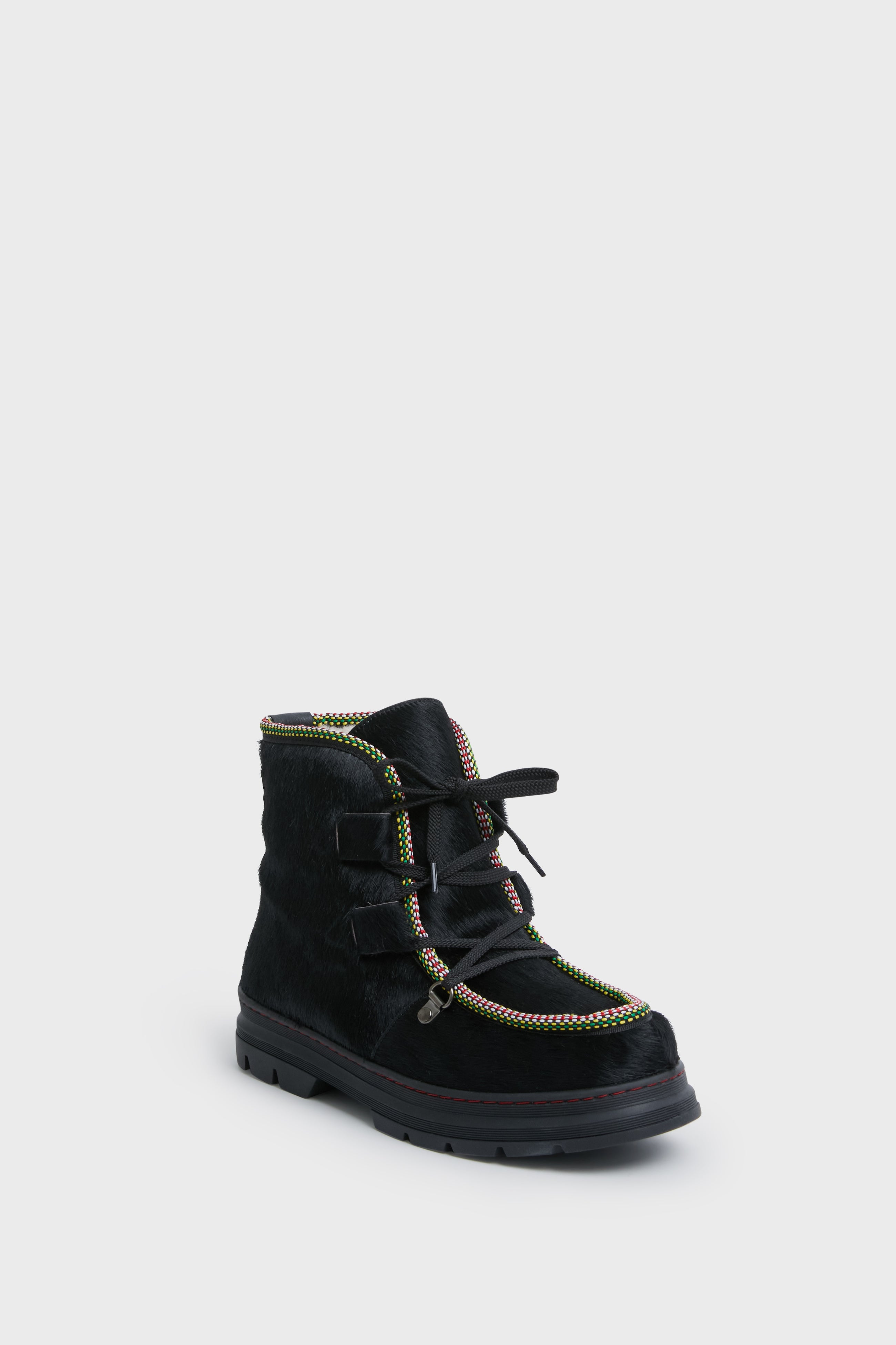 The Penelope Chilvers ankle boot features a textured black surface, multicolored trim, black laces, and a thick sole—perfect as cozy shearling-lined après ski footwear.