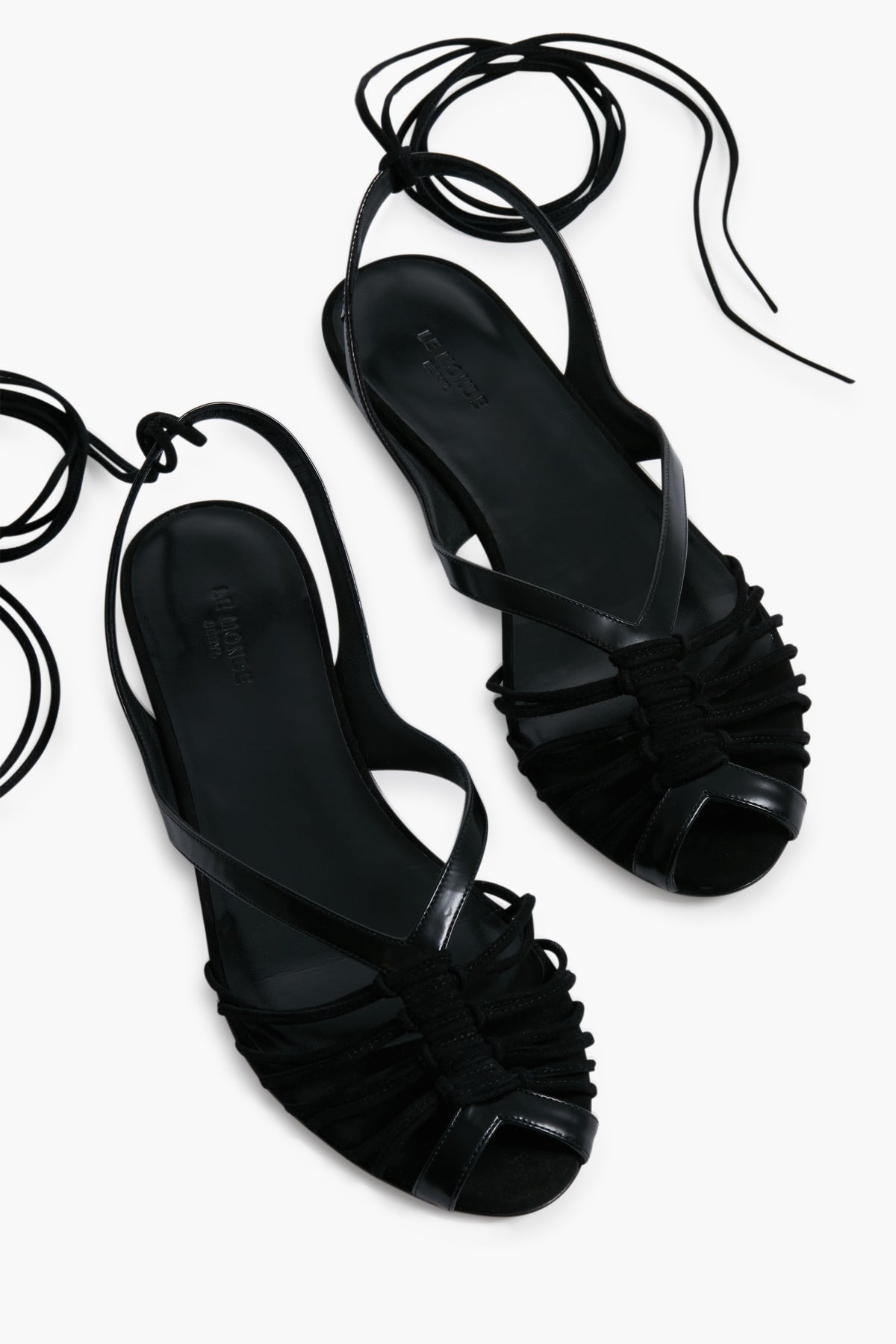 Le Monde Beryl’s black strappy Black Cage Sandals feature ankle wrap ties and open toes, inspired by handcrafted Italian footwear.