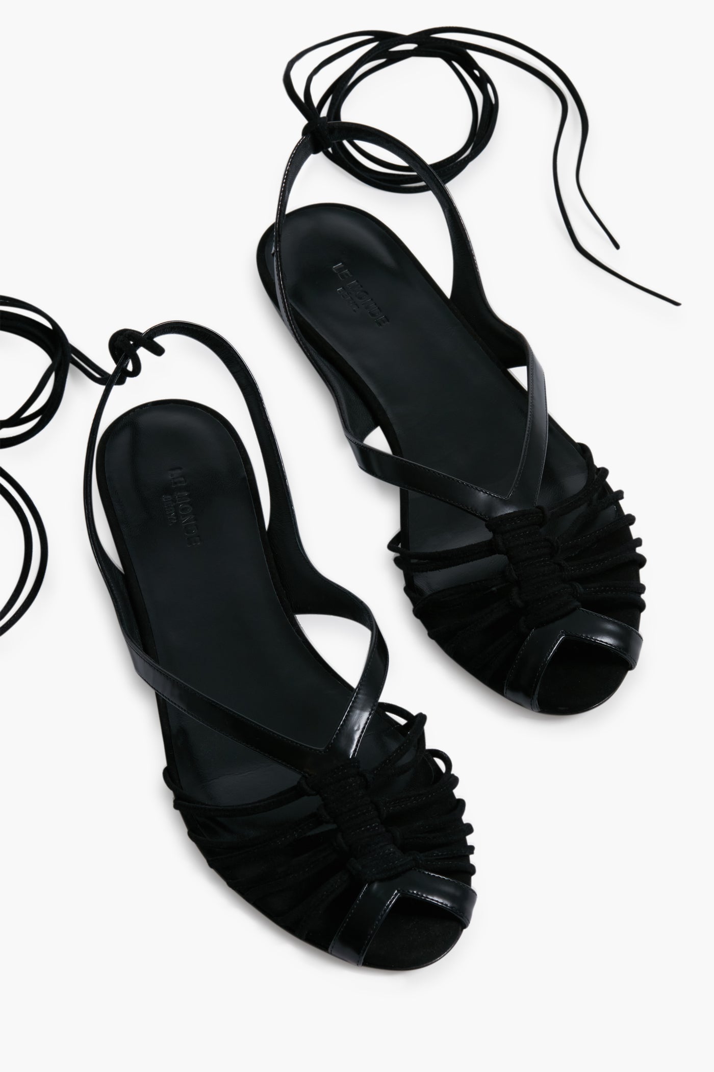 Le Monde Beryl’s black strappy Black Cage Sandals feature ankle wrap ties and open toes, inspired by handcrafted Italian footwear.