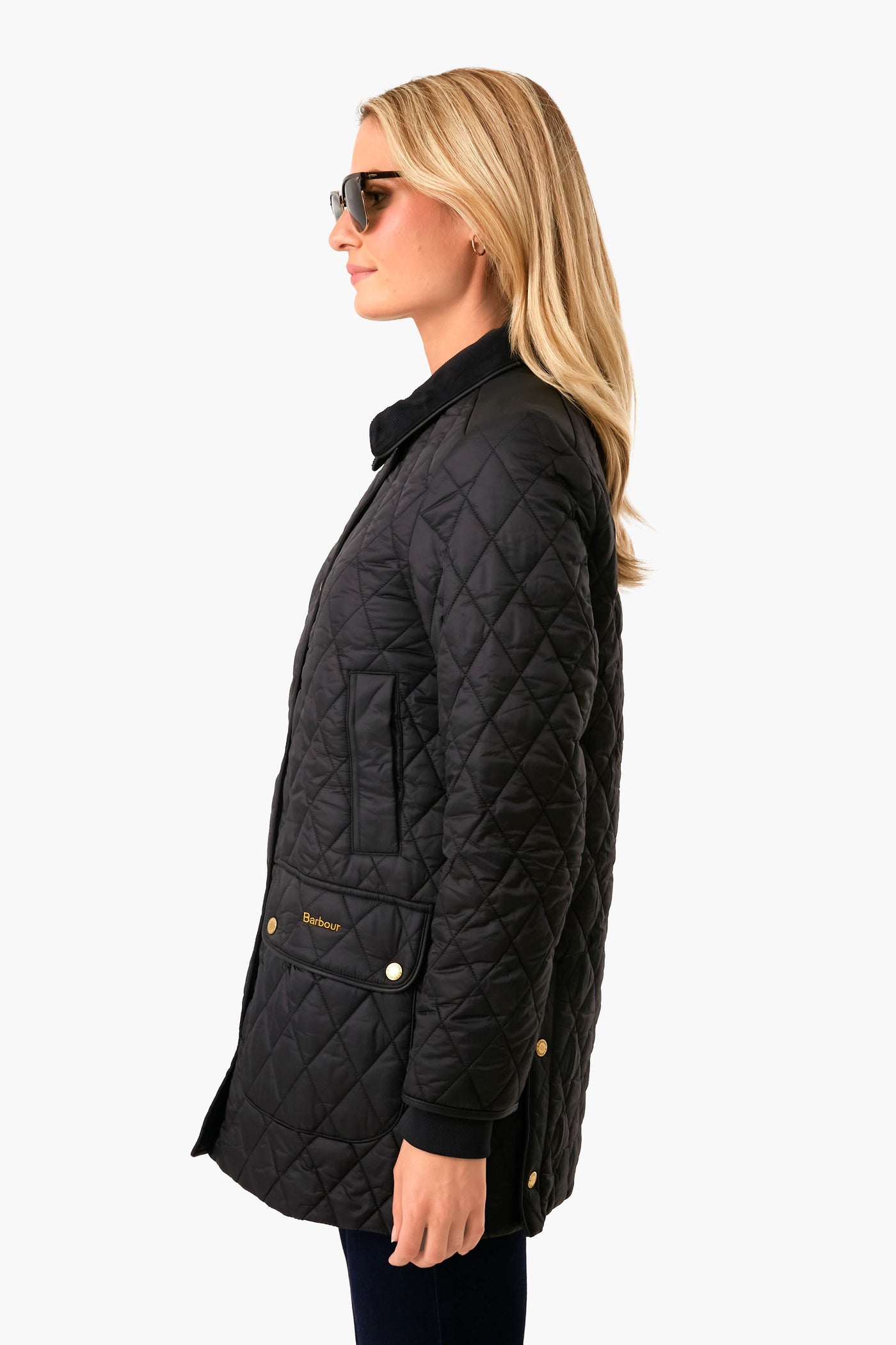 Woman in profile wearing a classic Black Kilmarie Quilt jacket with diamond stitching, gold-tone snap buttons, patch pockets, and corduroy collar, exuding high-end, effortless style.