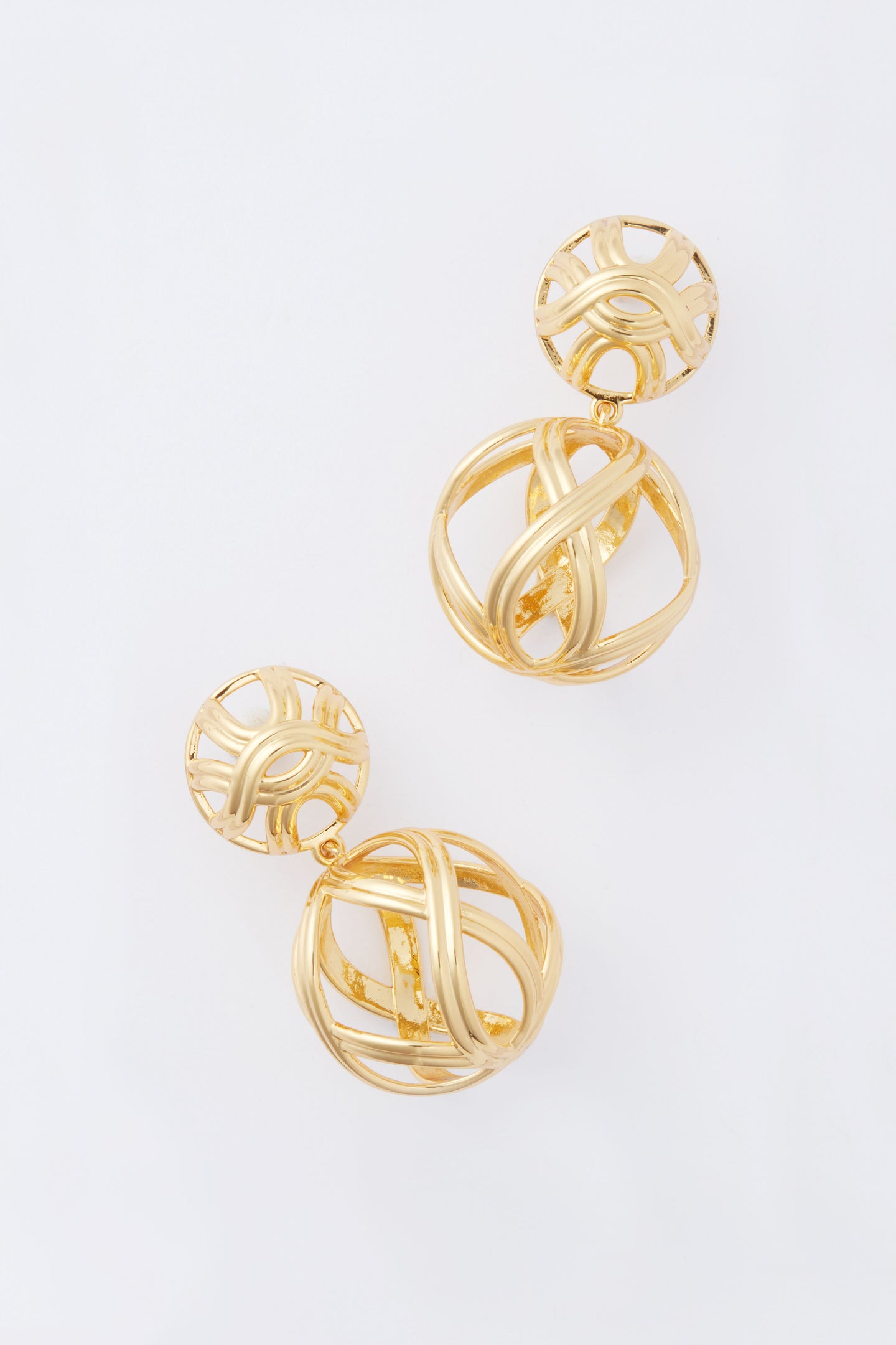 Tuckernuck Jewelry's gold birdcage earrings feature a striking spherical, open interwoven design that makes a bold statement.
