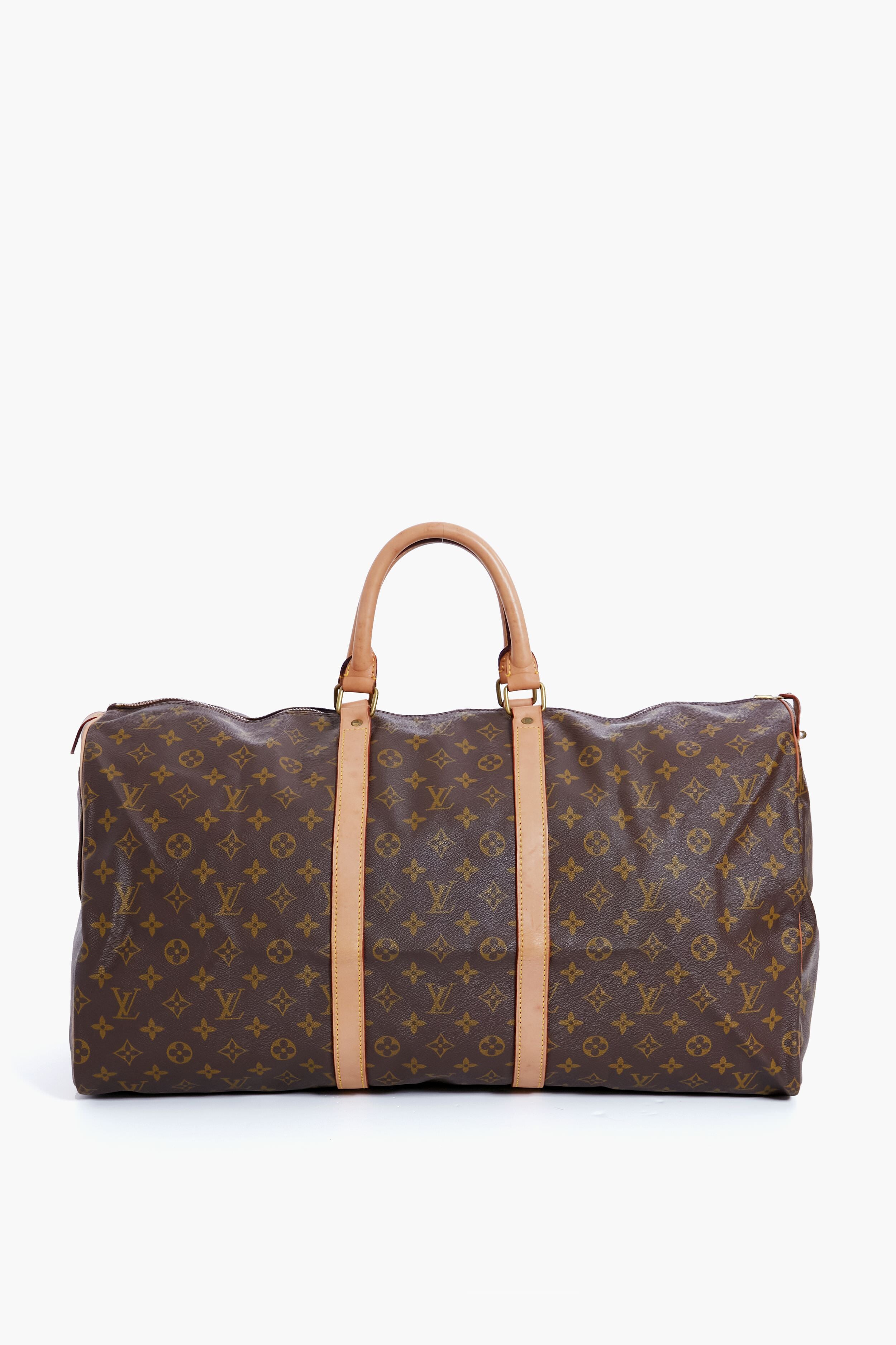 A brown Tuckernuck Archive Collection duffle bag with tan leather handles and accents, crafted from signature monogram canvas—a stylish luxury travel piece.