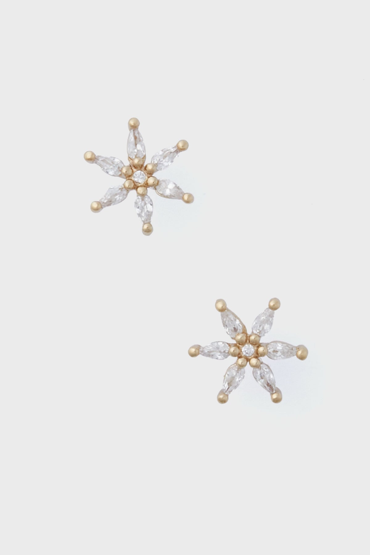 Mignonne Gavigan gold stud earrings feature six marquise-cut clear stones in a starburst design—unique jewelry that adds sparkle to any look.