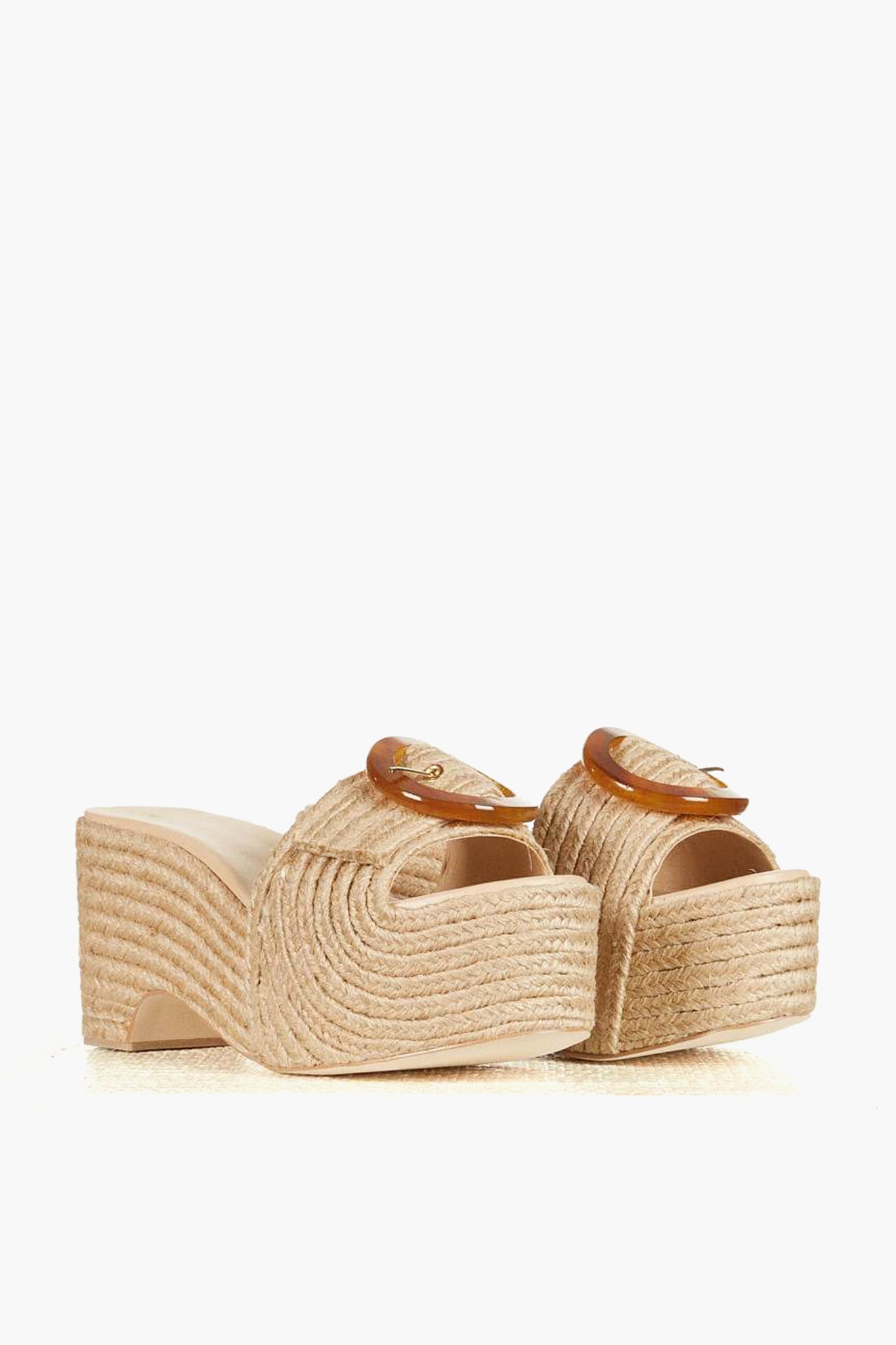 A pair of beige platform sandals by Cult Gaia featuring woven texture, chunky heels, open toes, and buckle strap details.