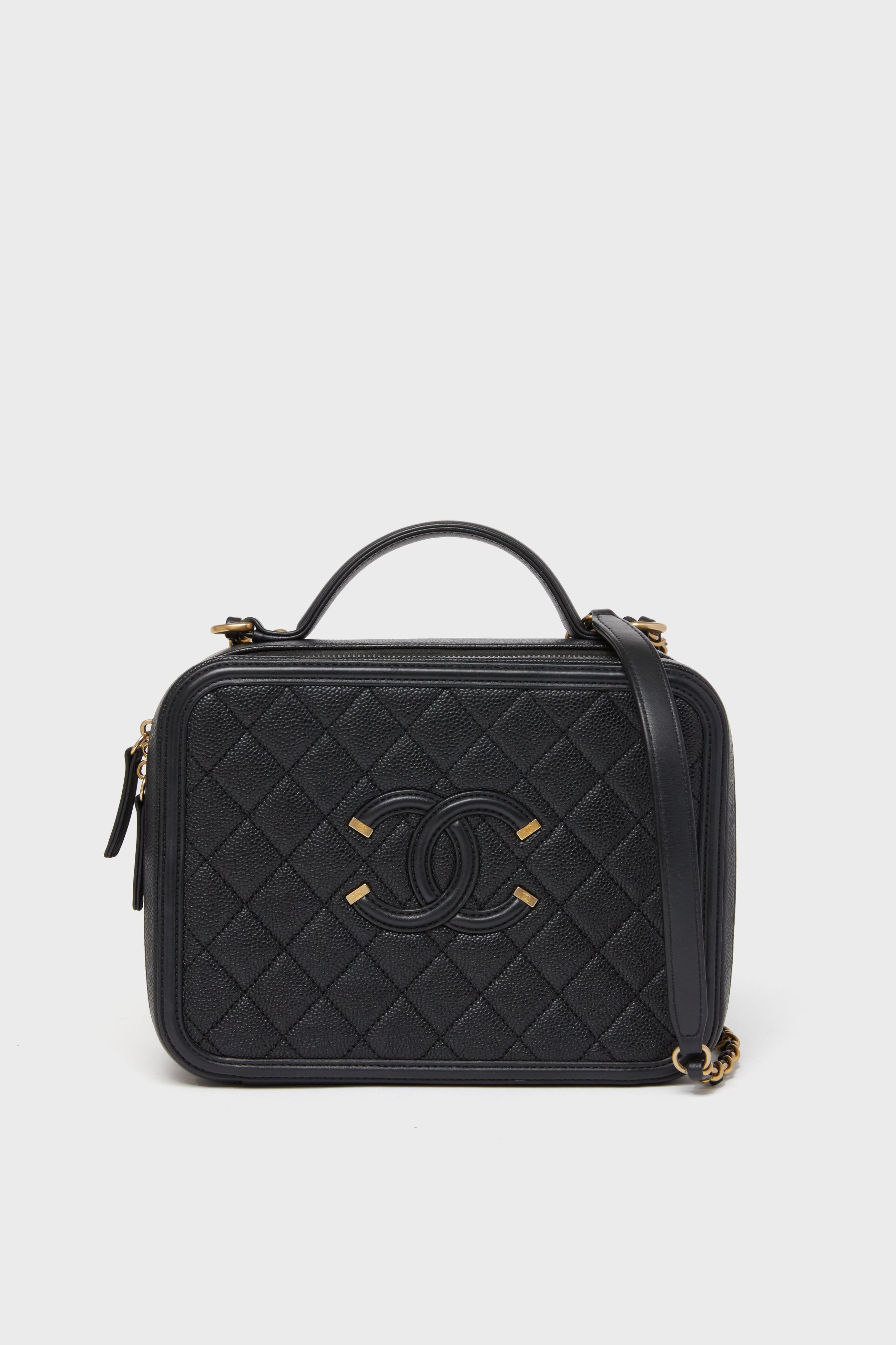 A Tuckernuck Archive Collection Classic Flap Bag in black quilted leather features a top handle, gold hardware, and the iconic front logo.