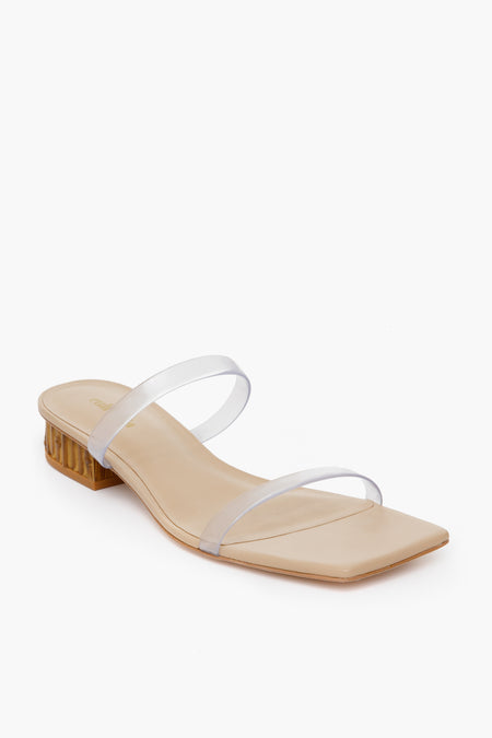 This beige sandal by Cult Gaia features a square toe, low block heel, and two transparent straps for a minimalistic summer look inspired by effortless style.