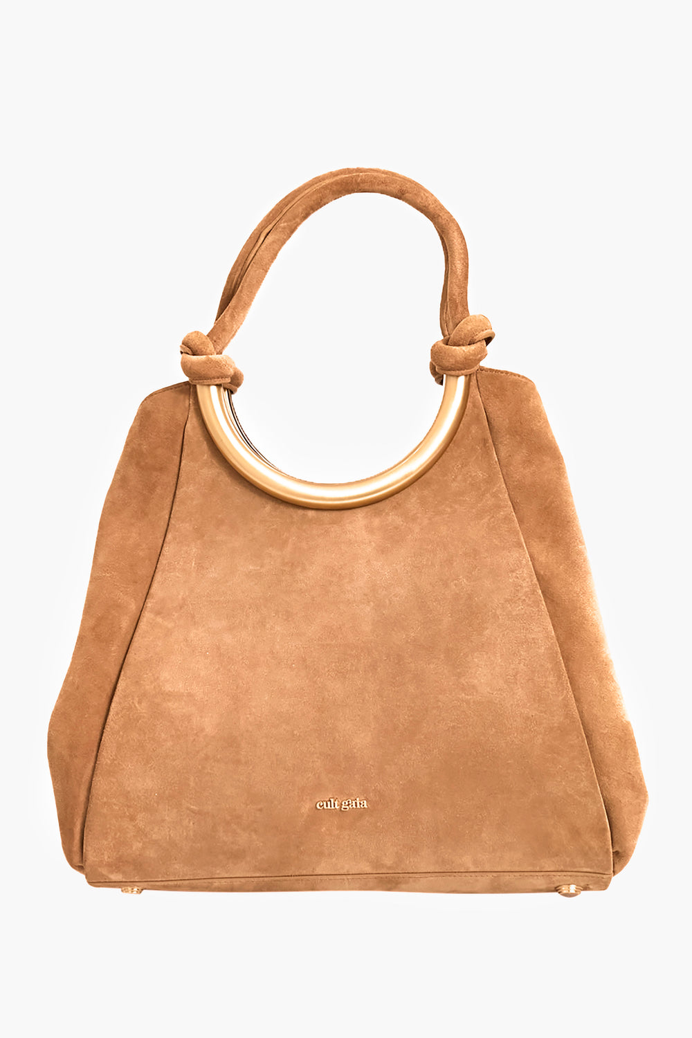 The Cult Gaia Nila Tote is a tan suede tote bag with a structured shape, gold circular handle, knotted suede shoulder straps, and the brand name near the bottom center.