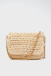 The Moda Luxe Annalise crossbody is a beige woven vegan leather handbag with a flap closure and gold chain strap.