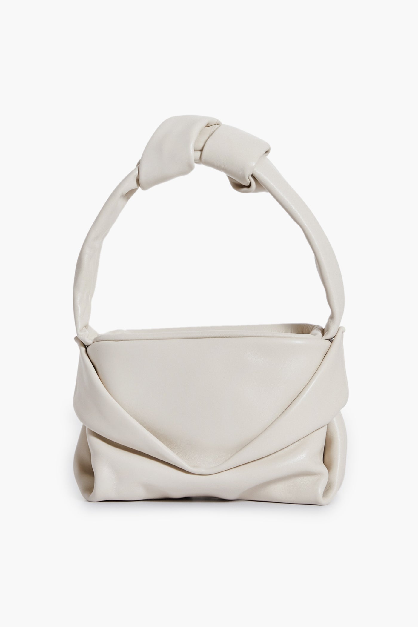 A cream lamb handbag by STAUD with a soft, folded design and thick knotted handle, reminiscent of the Cream Kiss Bag.