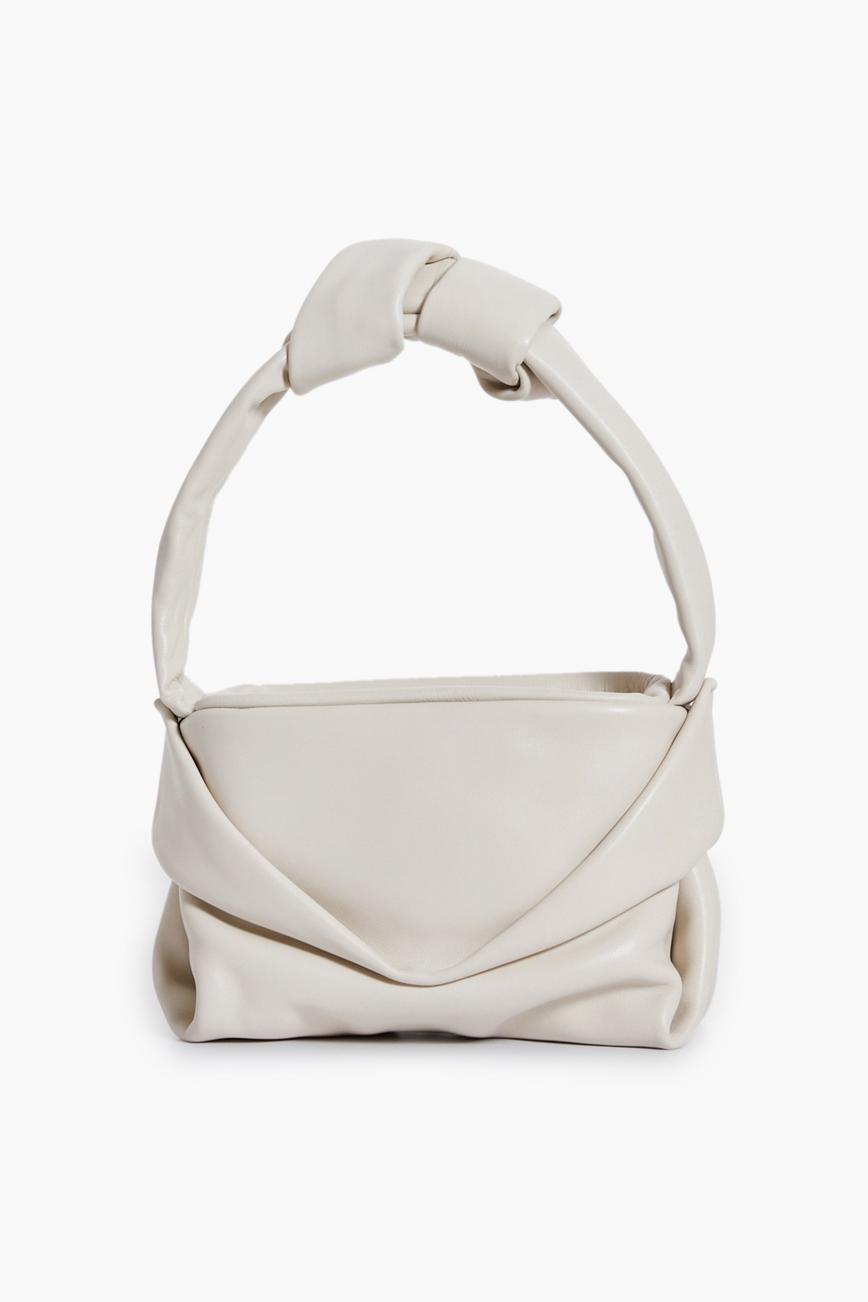 A cream lamb handbag by STAUD with a soft, folded design and thick knotted handle, reminiscent of the Cream Kiss Bag.