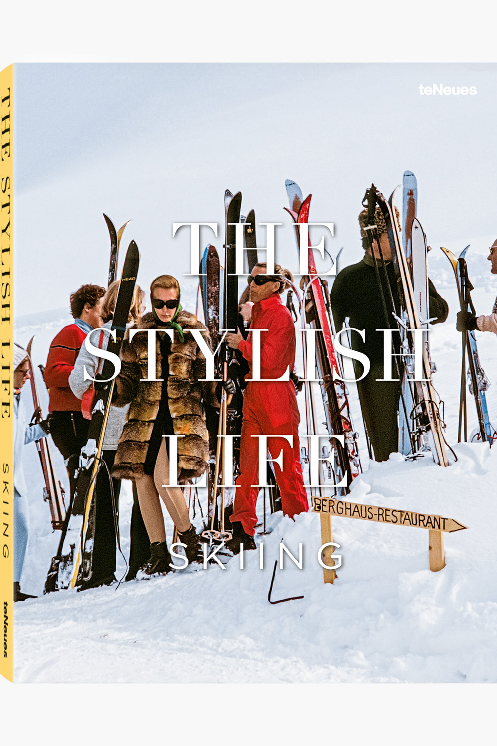 A group in ski gear stands with skis upright in the snow near a Berghaus-Restaurant sign; the Teneues magazine cover reads The Stylish Life: Skiing, celebrating the elegant ski lifestyle and alpine adventures.