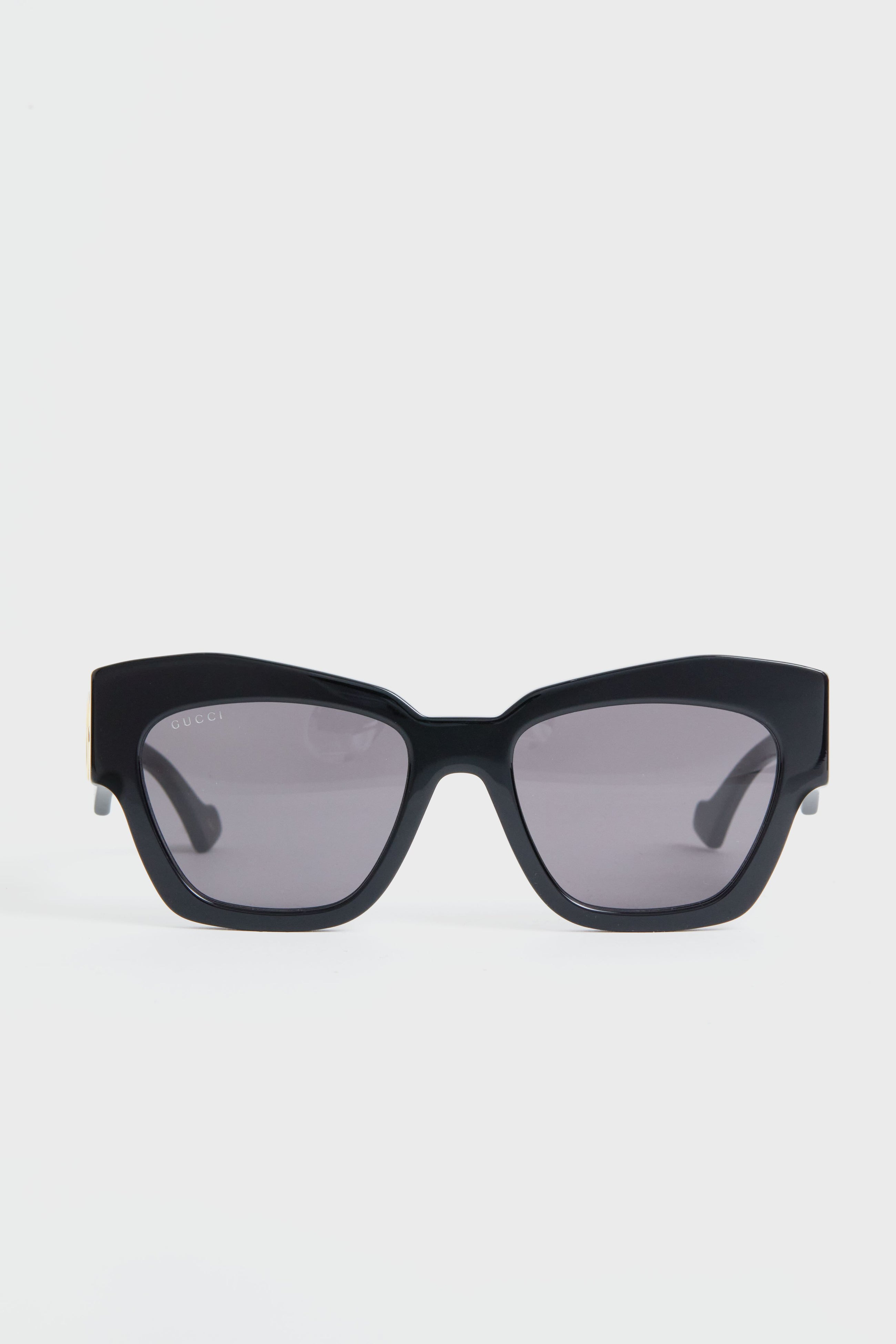 A pair of Gucci black rectangular sunglasses with dark tinted lenses, embodying luxury fashion.