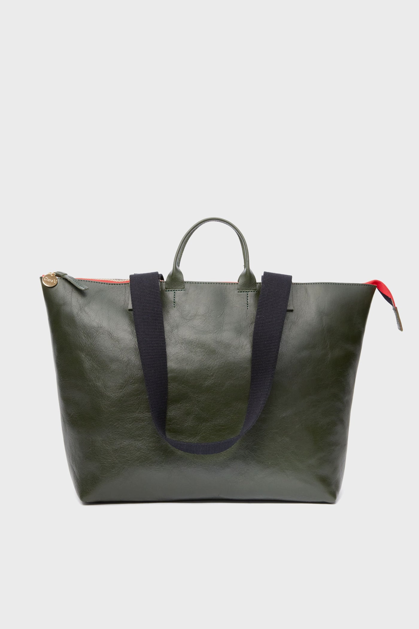 Clare V dark green Italian leather tote bag with short handles, black shoulder straps, red zipper pull, and secure zip closure.