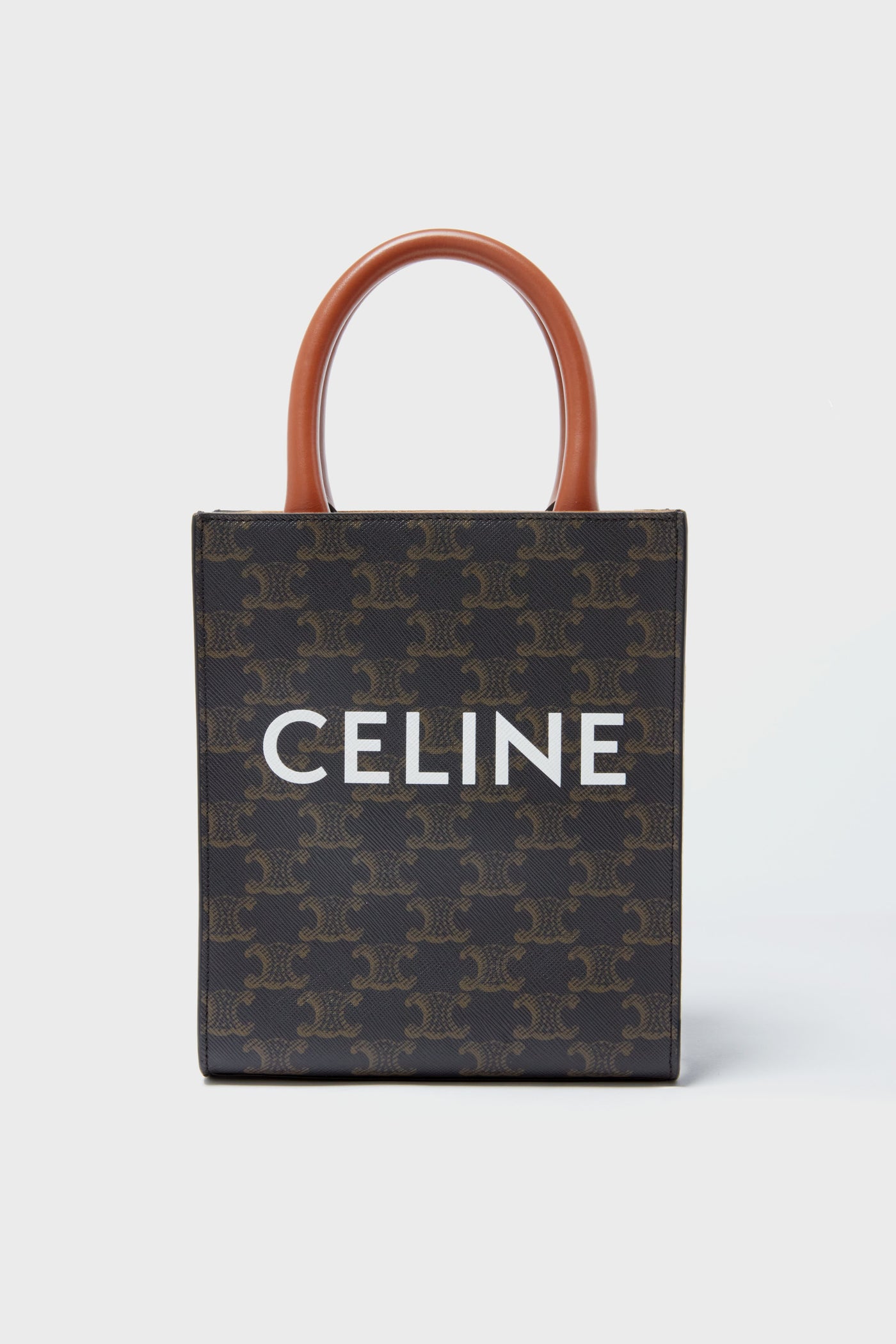 Rectangular Tuckernuck Archive Collection Mini Vertical Cabas Tote with brown handles and dark patterned exterior, featuring bold white lettering—a standout accessory among luxury leather bags.