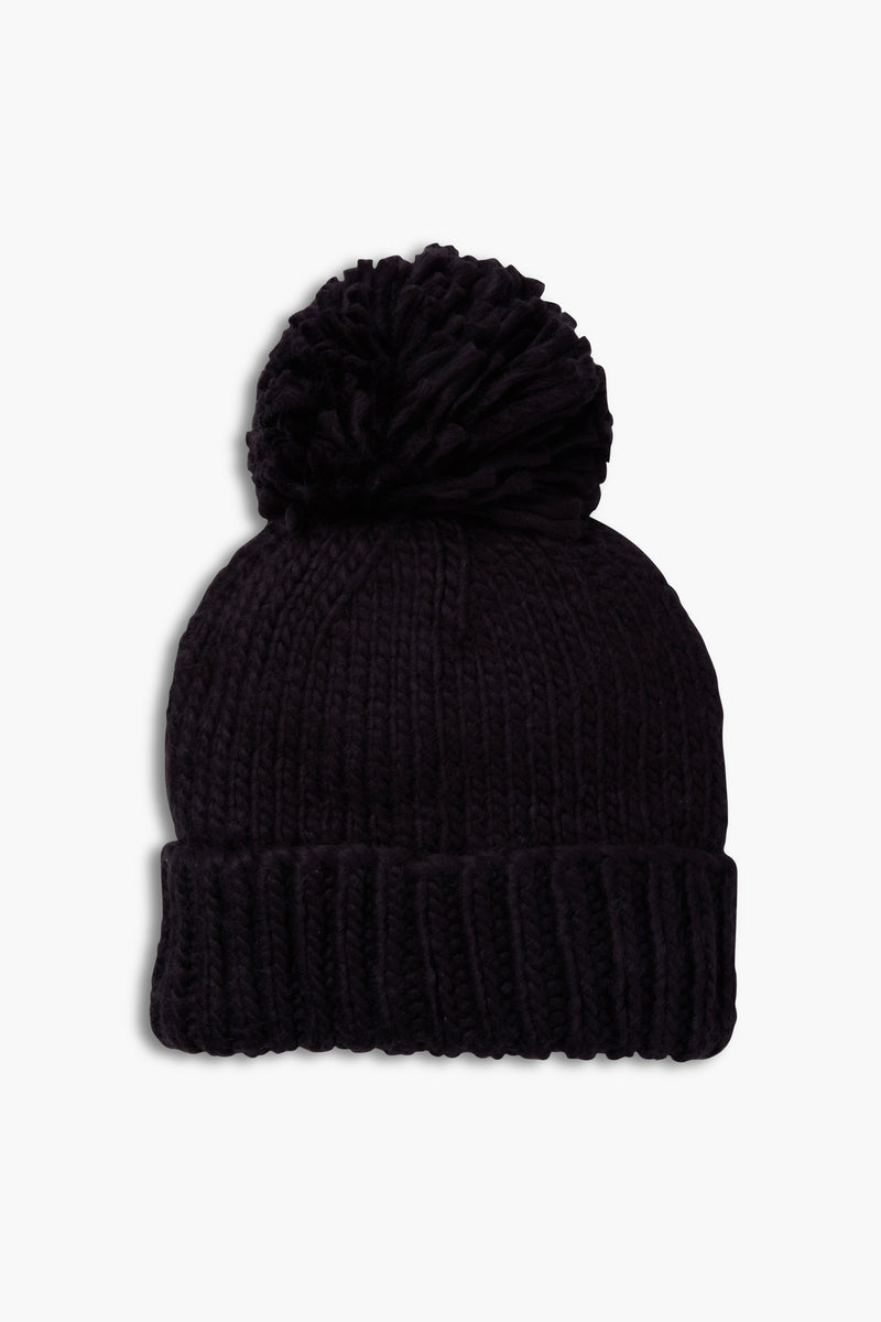 The Look by M black hand knit beanie features a folded brim and a large pom-pom on top.