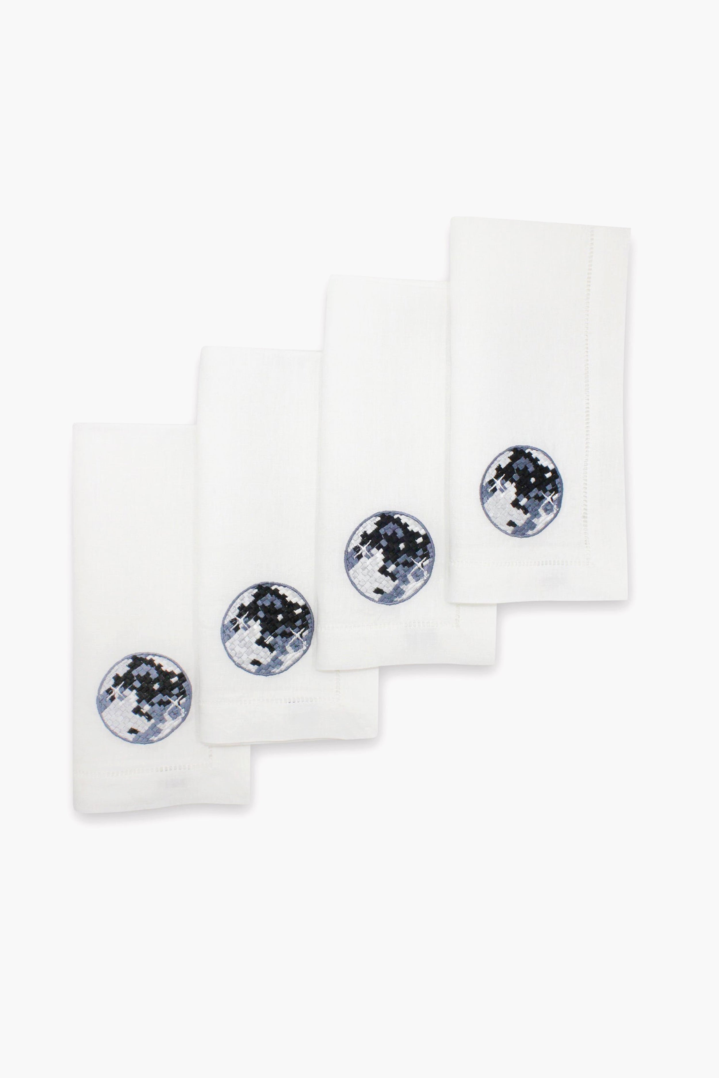 Set of four Chefanie white linen napkins, each with a circular embroidered patch in blue, black, and white—ideal disco ball dinner napkins to elevate any stylish tablescape.