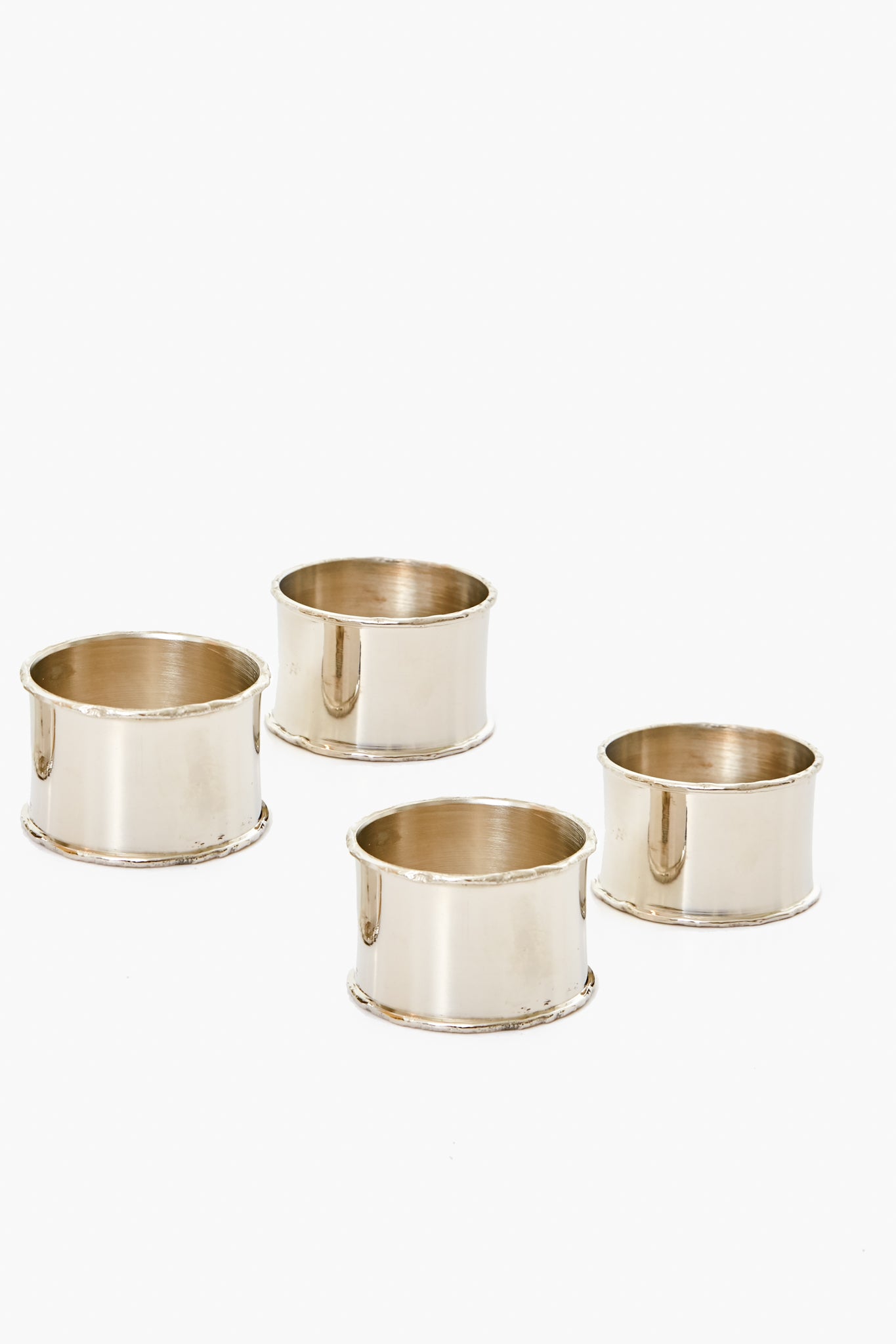 Four silver napkin rings from Caton's Wharf are arranged in a neat group, each showcasing their elegant style.