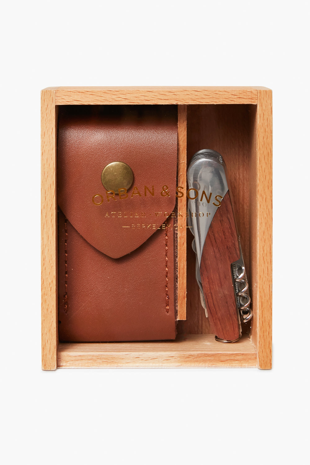 An Orban and Sons wooden box holds a brown leather carrying case with a brass button and a multi-function knife featuring a wooden handle.